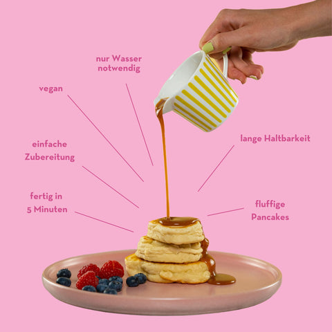 Ein Pancake-Stapel wird gerade mit Sirup übergossen, umgeben von Claims: 'Fertig in 5 Minuten', 'Einfache Zubereitung', 'Vegan', 'Nur Wasser notwendig', 'Lange Haltbarkeit', 'Fluffige Pancakes'.